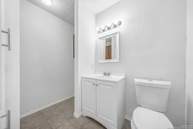 a bathroom with a toilet a sink and mirror