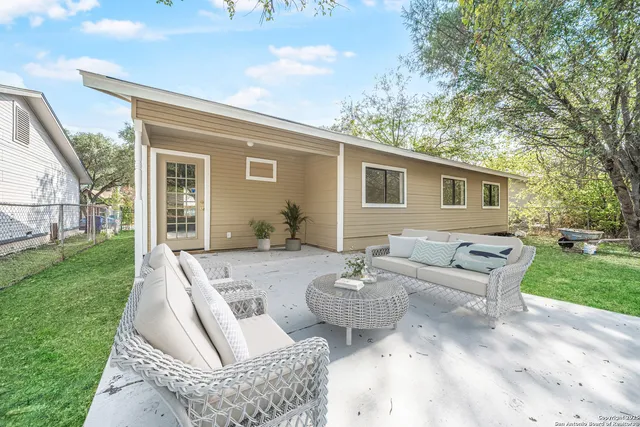 a view of a patio with couches chairs and a yard