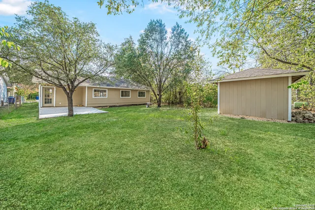 a view of a house with a yard and tree s
