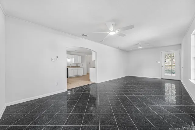 a view of an empty room and window chandelier fan