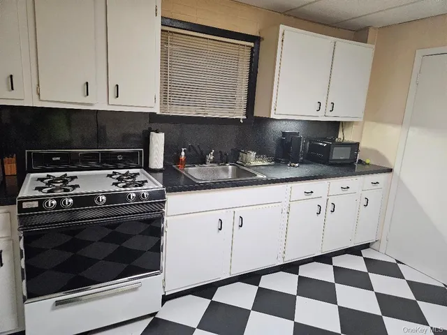 a kitchen with granite countertop white cabinets and appliances