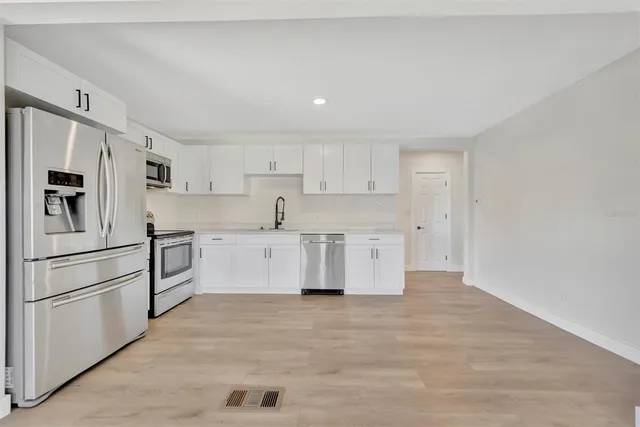 a kitchen with stainless steel appliances a refrigerator sink and cabinets