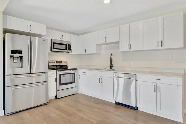 a kitchen with white cabinets and white appliances