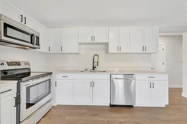 a kitchen with stainless steel appliances granite countertop a sink and a stove