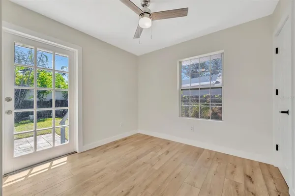 a view of empty room with wooden floor and fan