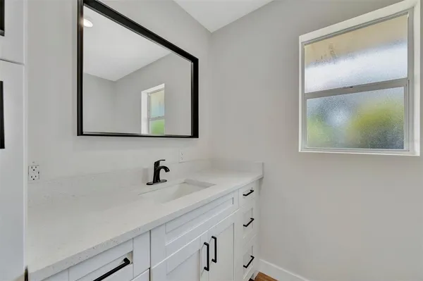 a bathroom with a sink mirror and vanity