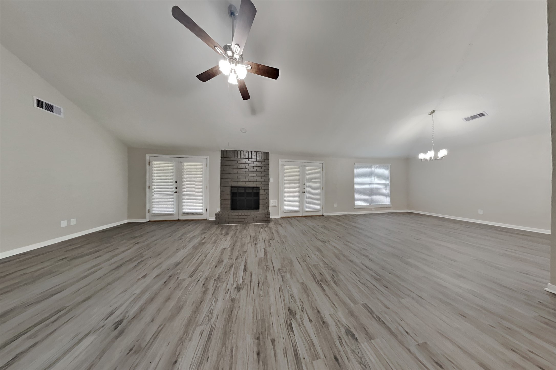 6818 White Tail Drive Spring, TX 77379 - Photo 3 of 24 an empty room with wooden floor chandelier fan and windows