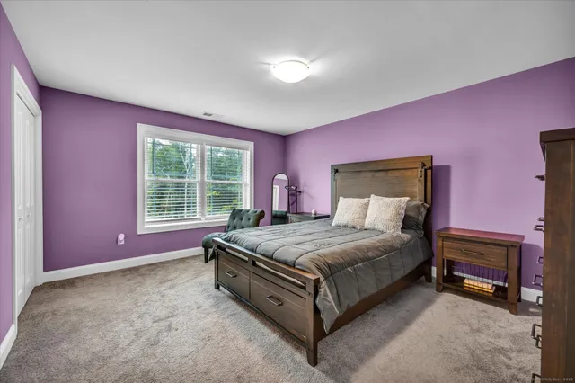 a spacious bedroom with a bed and a window