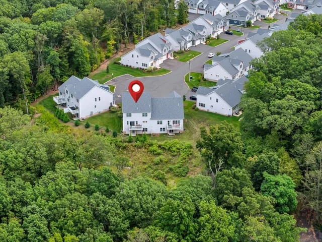 an aerial view of residential house with outdoor space and trees all around