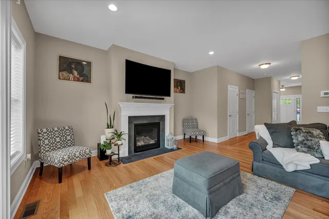 a living room with furniture a flat screen tv and a fireplace