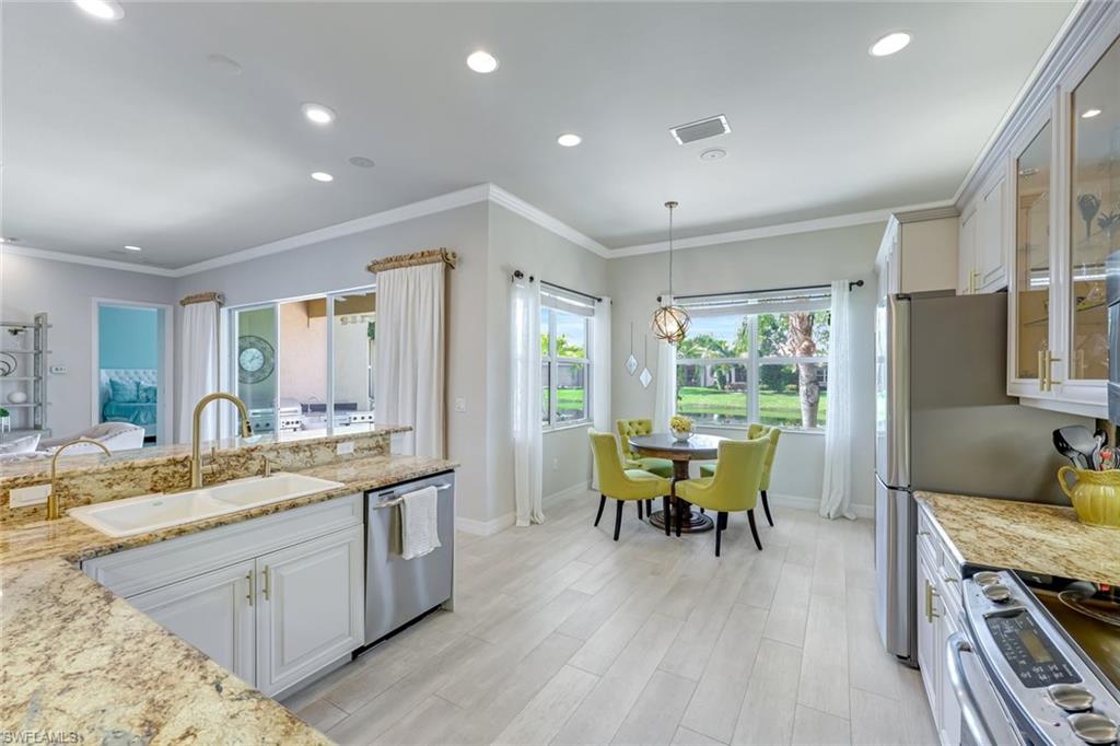 6582 Monterey Point Naples, FL 34105 - Photo 8 of 28 a kitchen with a table chairs and wooden floor