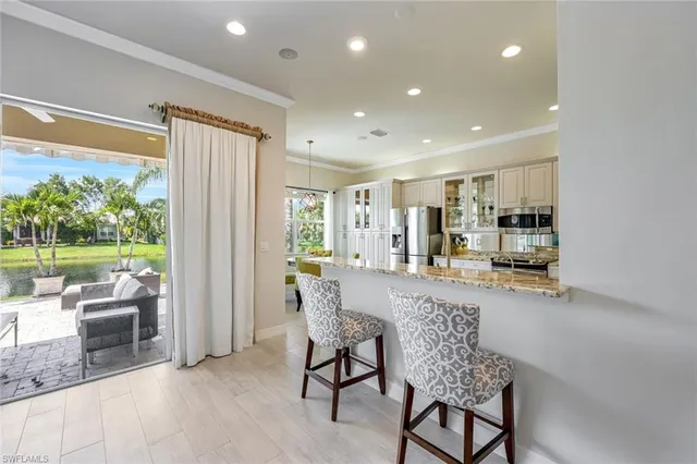 a dining room with wooden floor a chandelier a wooden table and chairs