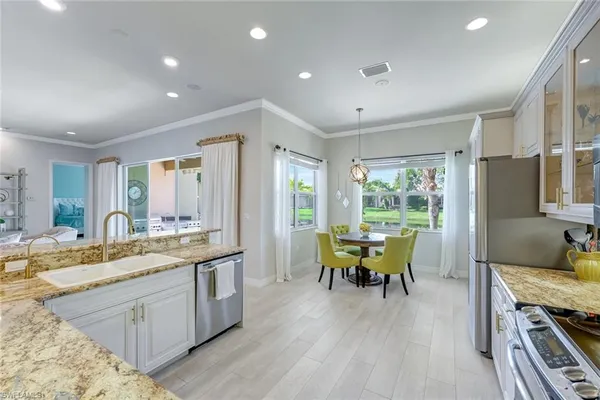 a dining room with wooden floor a chandelier a wooden table and chairs