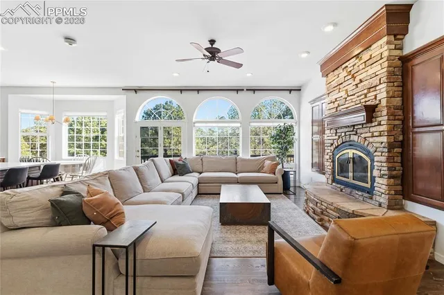 a living room with furniture fireplace and a large window