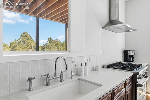 a kitchen with stainless steel appliances granite countertop a sink a stove and a wooden floor