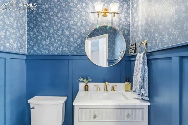 a bathroom with a sink a toilet and a mirror