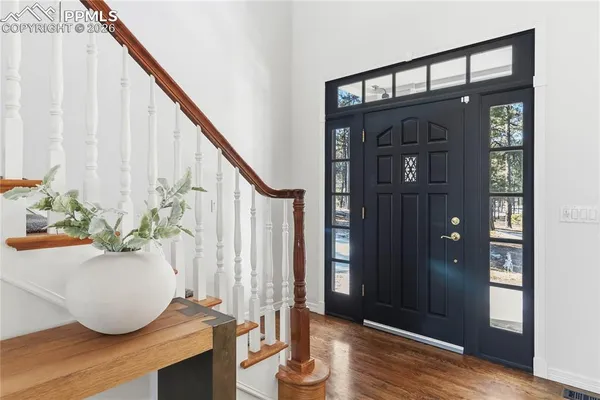 a view of entryway and hall with wooden floor