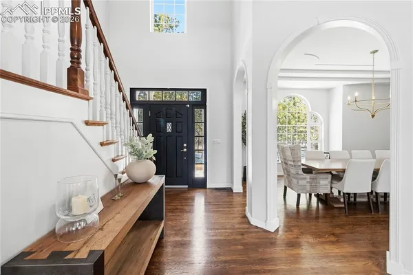 a dining room with wooden floor table and chairs