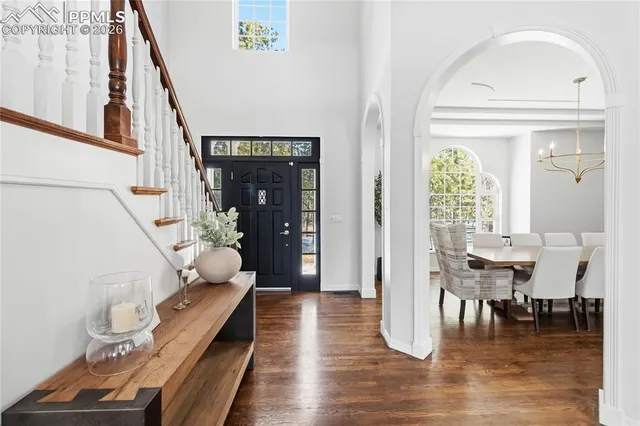 a dining room with wooden floor table and chairs