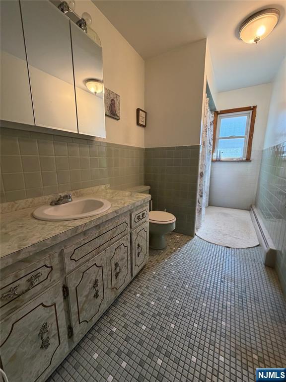 79 Hunter Street Lodi, NJ 07644 - Photo 11 of 11 a bathroom with a sink a toilet and mirror