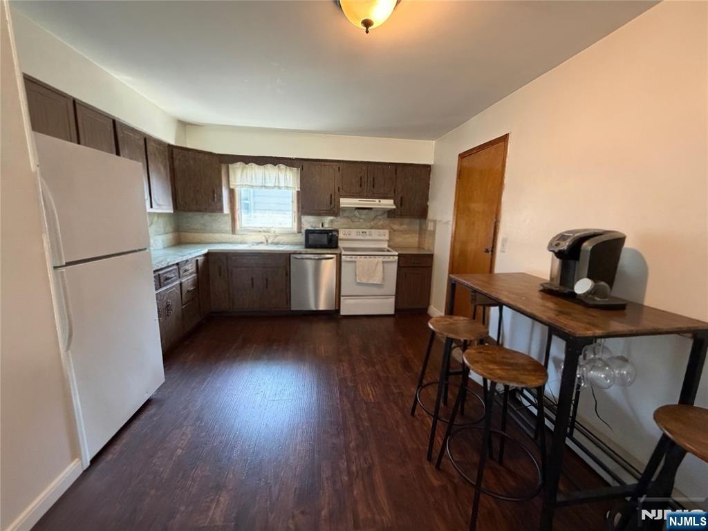 79 Hunter Street Lodi, NJ 07644 - Photo 6 of 11 a kitchen with a refrigerator and a stove top oven