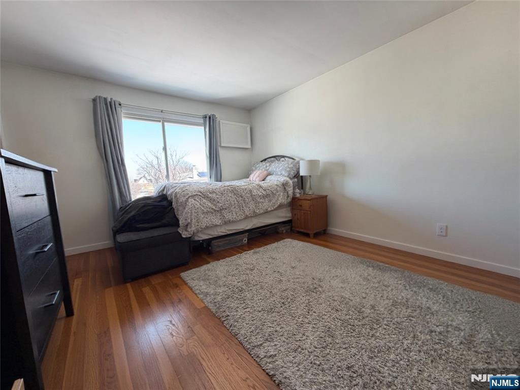 79 Hunter Street Lodi, NJ 07644 - Photo 8 of 11 a bedroom with a bed and wooden floor