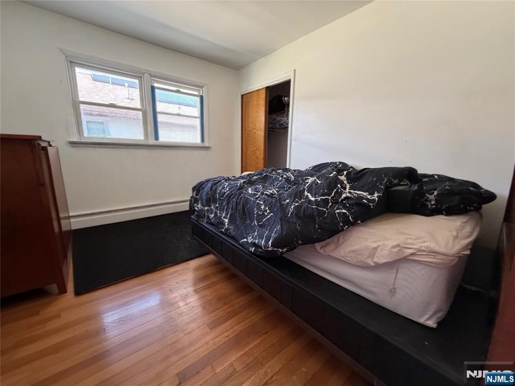 79 Hunter Street Lodi, NJ 07644 - Photo 10 of 11 a bedroom with a bed window and wooden floor