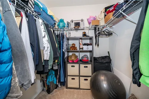 a view of walk in closet with clothes and shoes