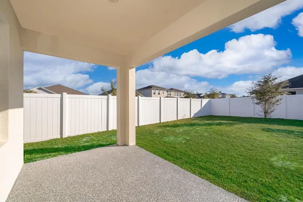 an aerial view of a house with a yard and greenery