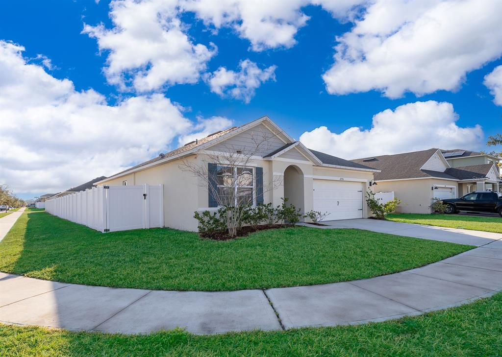 2795 Harmonia Hammock Road St. Cloud, FL 34773 - Photo 3 of 30 a view of a white house with a big yard and a large tree