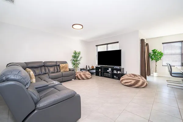 a living room with furniture a flat screen tv and a large window