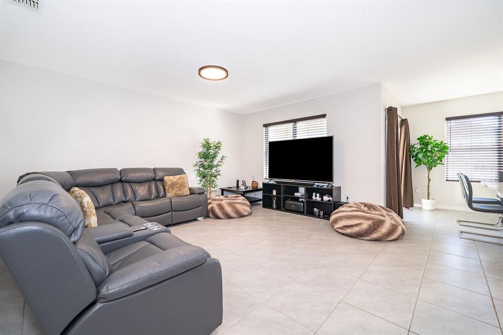 2795 Harmonia Hammock Road St. Cloud, FL 34773 - Photo 10 of 30 a living room with furniture a flat screen tv and a large window