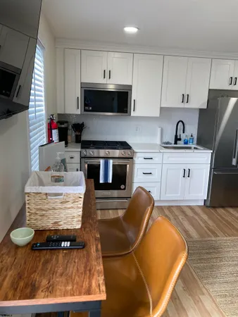 a kitchen with kitchen island a stove a sink a microwave and cabinets