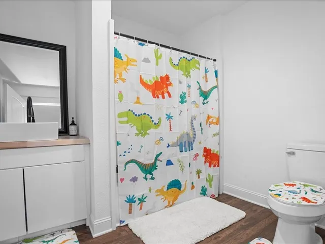 a bathroom with a sink a mirror and painting on the wall