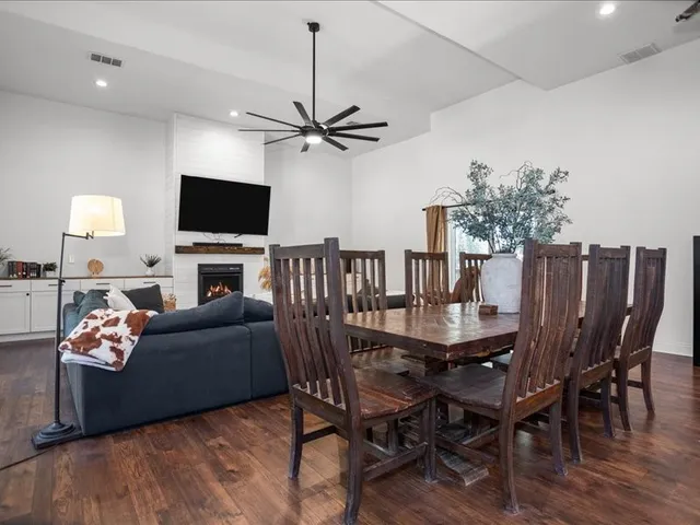 a living room with furniture a flat screen tv and kitchen view