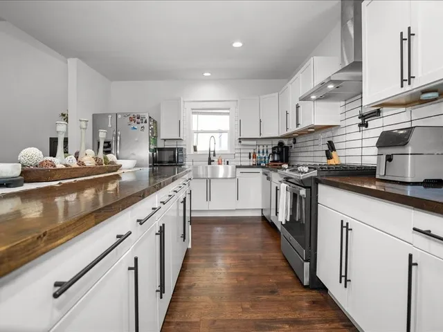 a kitchen with stainless steel appliances granite countertop lots of counter top space a sink a stove and a refrigerator