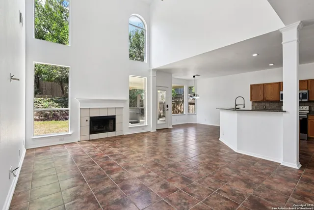 a view of empty room with kitchen view and a window