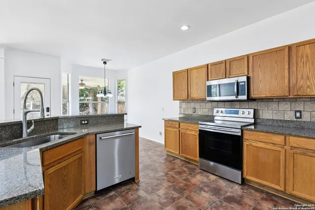a kitchen with stainless steel appliances granite countertop a stove sink and microwave