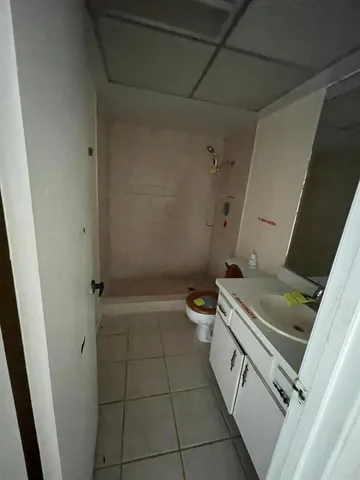 a bathroom with a granite countertop sink toilet and shower