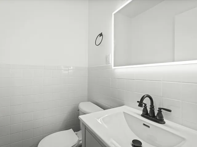 a bathroom with a toilet sink and mirror