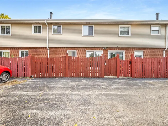 a view of a parking space and a car parked in front of a house