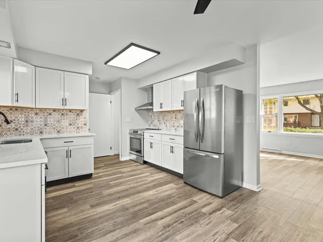 a kitchen with a refrigerator stove and white cabinets