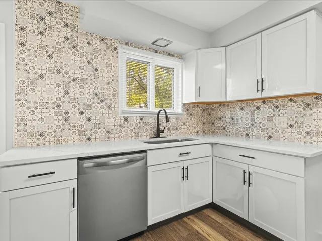 a kitchen with stainless steel appliances white cabinets and a sink