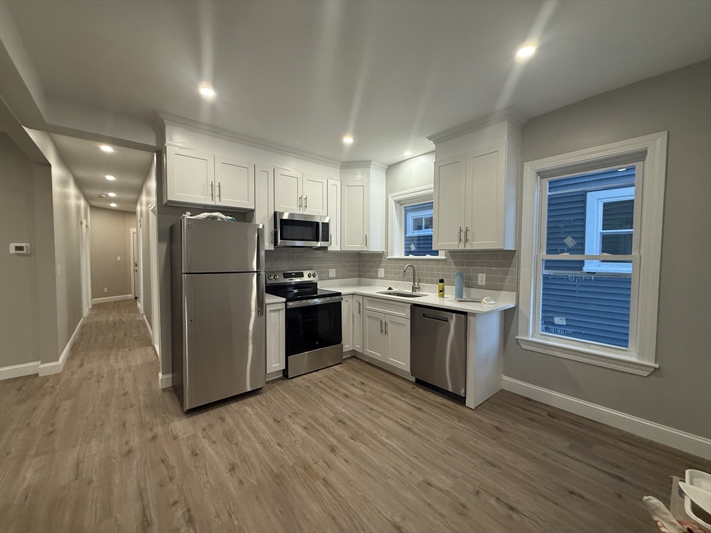 a kitchen with a refrigerator sink and cabinets