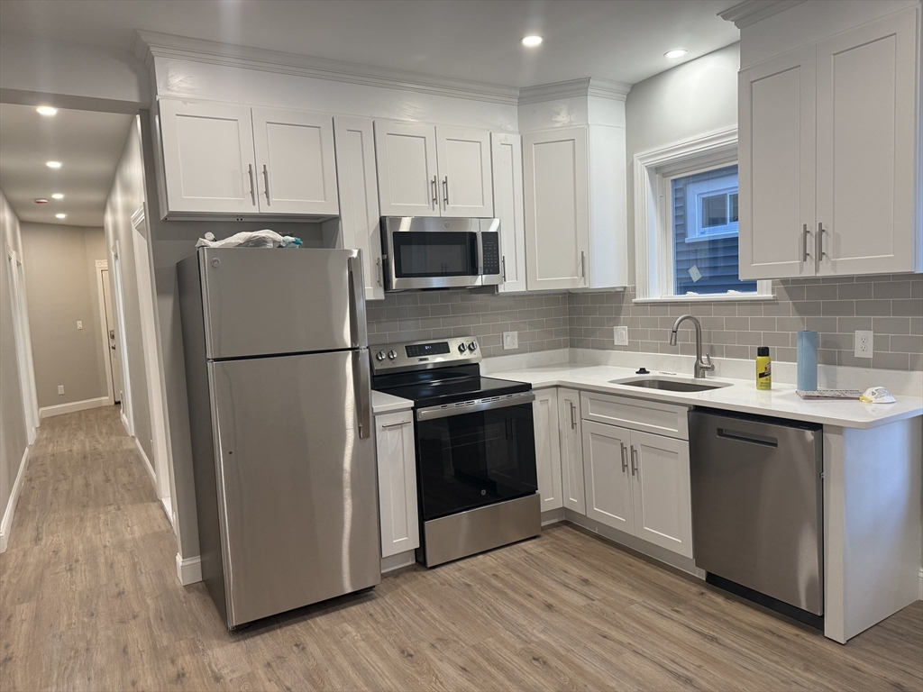 19 Dewolf Street, Unit 1 Boston, MA 02125 - Photo 2 of 12 a kitchen with a refrigerator stove and sink