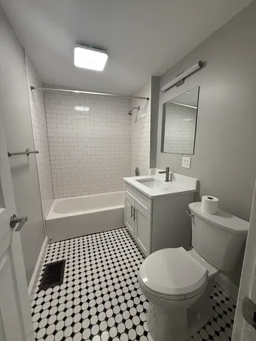 a bathroom with a sink a toilet a mirror and shower
