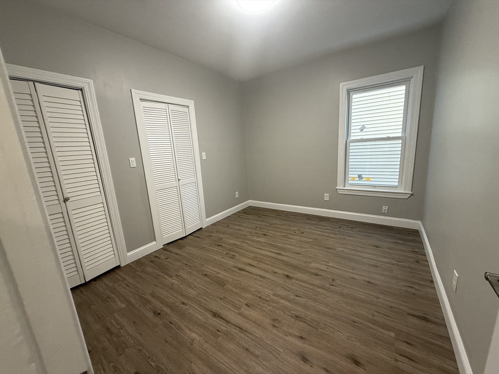 19 Dewolf Street, Unit 1 Boston, MA 02125 - Photo 8 of 12 an empty room with wooden floor and windows