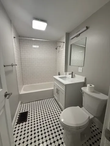 a bathroom with a sink a toilet a mirror and shower