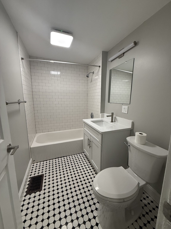 19 Dewolf Street, Unit 1 Boston, MA 02125 - Photo 9 of 12 a bathroom with a sink a toilet a mirror and shower