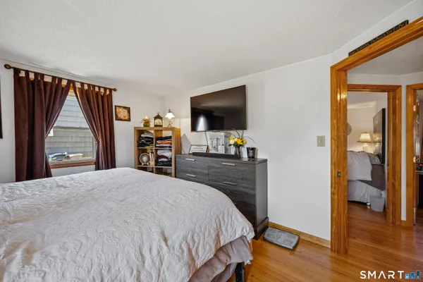 a bedroom with a bed and a flat tv screen on a dresser